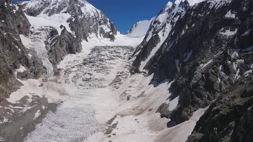 Observe the Stunning Aerial View of Glacial Landscape in Majestic Mountain Range From Above