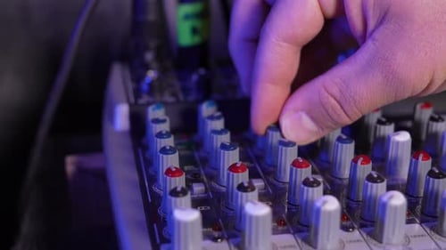 Close-up of sound mixer console in recording studio. Male hands