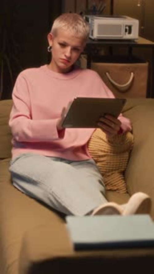 Woman Relaxing on Couch Using Tablet at Home