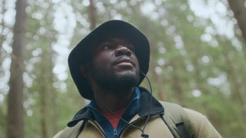 Black Man Drinking Water While Hiking in Woods