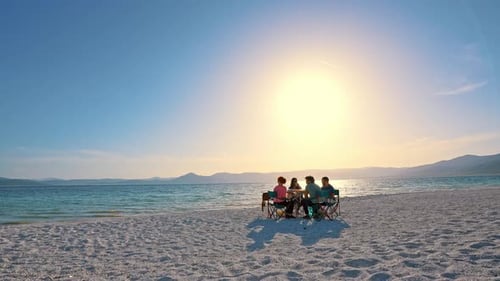 Sitting Around Table on the Beach at Sunset