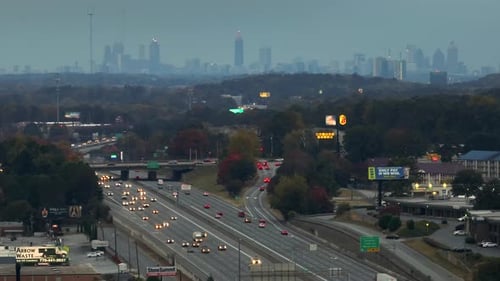 American Freeway with Fast Driving Cars and Trucks and Highrise Skyscrapers of Atlanta City in