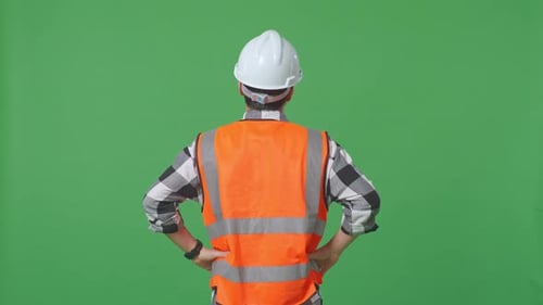 Back View Of A Male Engineer Looking Around While Standing With Arms Akimbo In The Green Screen