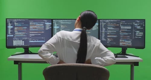 Asian Woman Developer Having Backache While Write Code With Multiple Screens In Green Screen Studio