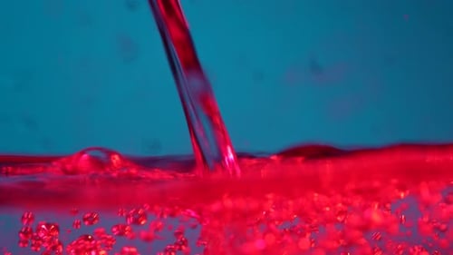 Vibrant Fluid Motion: Red Water Bubbles in Blue Background