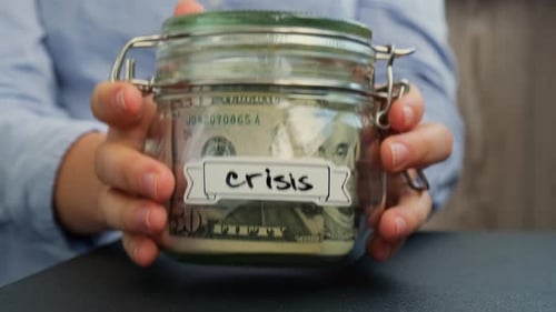 Glass Jar with Money Labeled Crisis