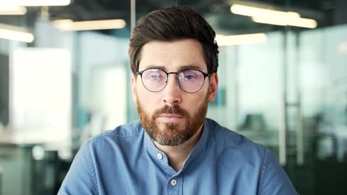 Webcam view. Businessman in glasses watching video call training looking at camera while sitting