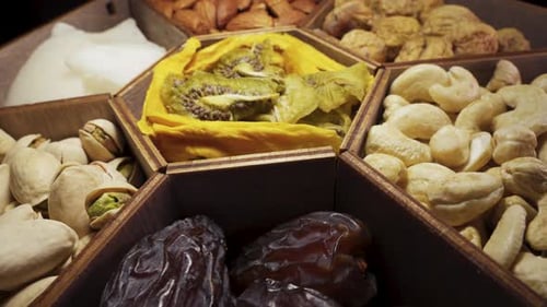 A set of dried fruits and nuts in a wooden box. Rotate close-up.