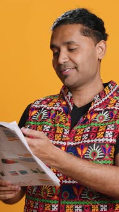 Vertical Video Worker Looking Over Paperwork Graphs Studio Background
