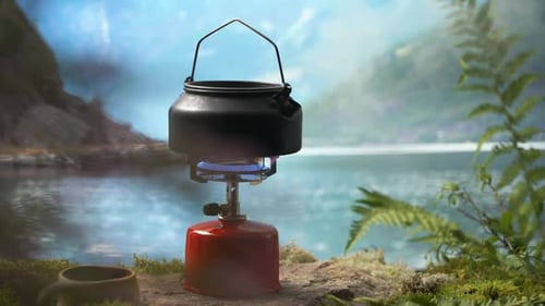 Kettle Boils on a Camping Stove by a Lake