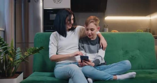 Mother and Child Bonding over Smartphone on Couch