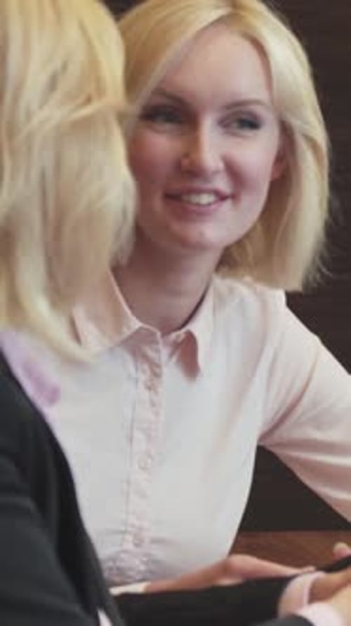 Engaged Women Share Ideas with Smiles in a Modern Office Setting