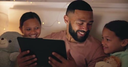 Father and Daughters Play with Tablet in Bed