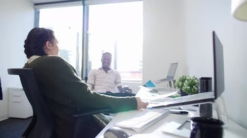 Smiling Young Business People Talking And Laughing In Sunny Office