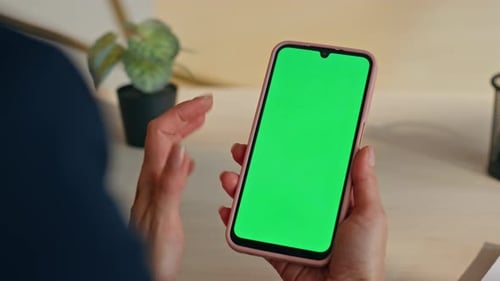 Woman Using Smartphone with Green Screen Display