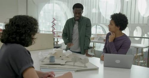 Architects in Office Discussing Urban Planning, Looking at Architecture Model