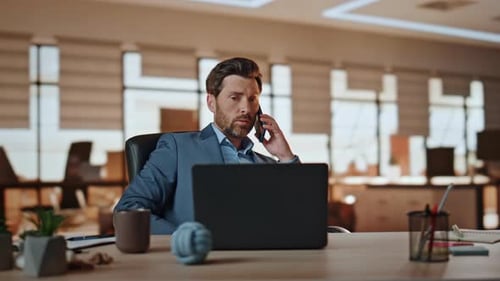 Man Talks on Phone at Office Desk