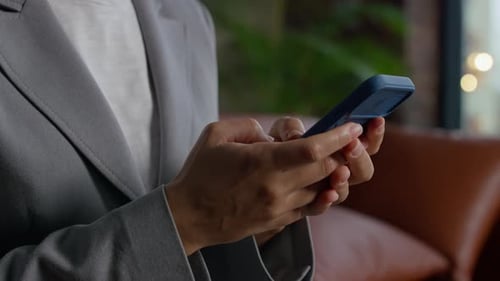 Woman in Blazer Uses Phone Inside Apartment