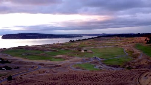 Aerial overlooking golf course with evening stormcouds on the horizon.