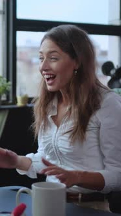 A Focused Young Woman is Working Diligently at Her Desk in a Modern Office Environment