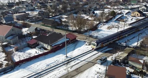 Luftaufnahme eines verschneiten Ortes mit einem Zug