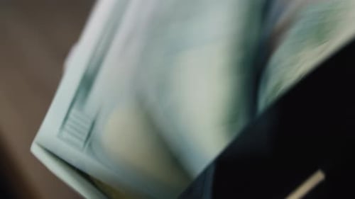 Primer plano de la máquina contadora de efectivo que cuenta billetes de cien dólares