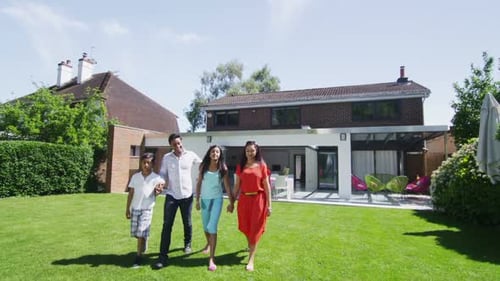 Positive family resting on lawn near building at sunset