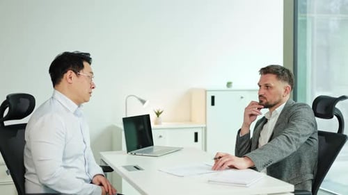 Business Meeting Korean and Caucasian Businessmen Discuss Strategy in a Modern Office