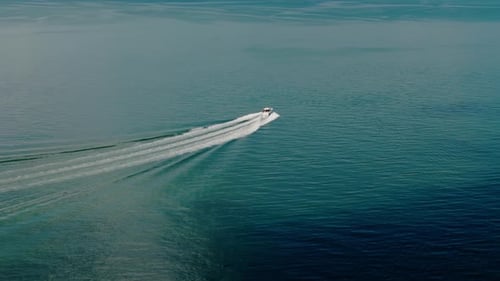 Drone Wide View of a White Boat Sailing to the Blue Sea Moving at High Speed