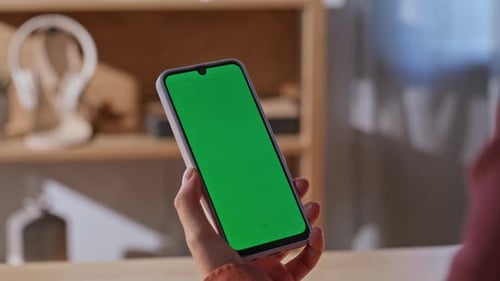 Hand Holds Phone with Green Screen for Compositing