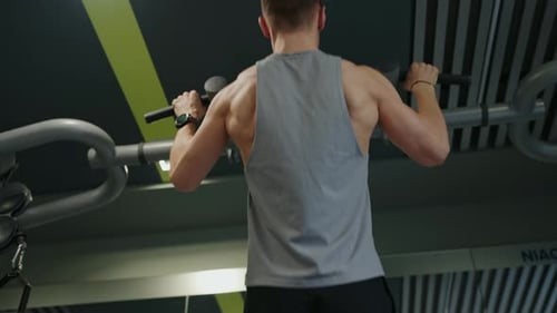 Back View on Sporty Man Doing Pull Up Exercises in Fitness Center