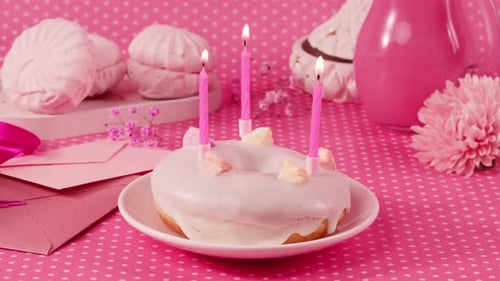 Donut Cake With Pink Candles On Pink Background