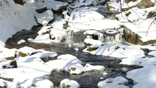 A peaceful shot of a small creek winding its way through a small serene winter landscape.