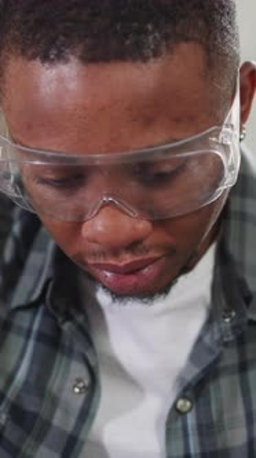 AfricanAmerican Man with Goggles Works Sitting on Sofa
