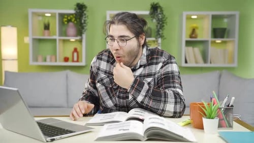 Man Talks in Virtual Meeting at Desk Indoors