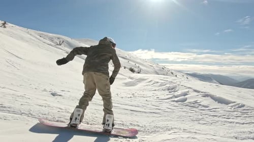Snowboarder Doing 360 in Backcountry on a Bluebird Day