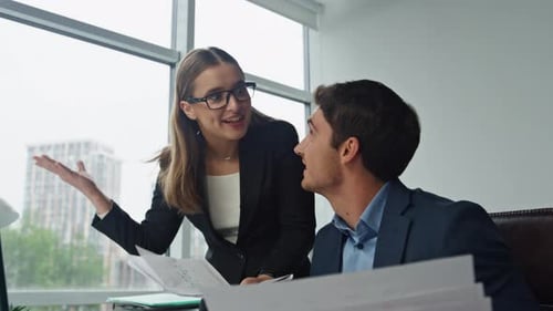 Two Employees Discussing Project in Office