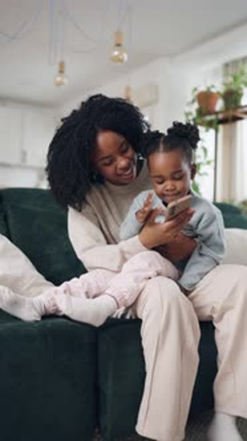 Woman and Child Looking at a Cell Phone Indoors