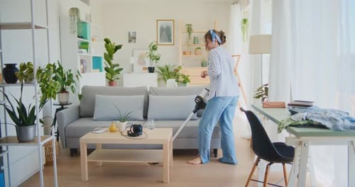 Woman Vacuums Floor in Bright Living Room