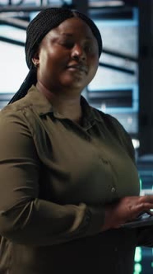 Woman Working on Laptop in Data Center