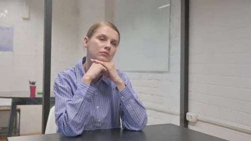 Woman Thoughtfully Ponders in Office Workplace Setting