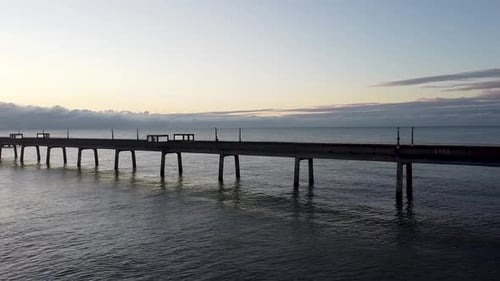 Niedriger Winkel bei Sonnenaufgang, Luftbild von hinten nach rechts über den Deal Pier, die Promenade von Kent, das Wahrzeichen des Ozeans