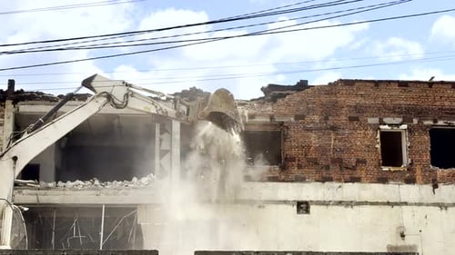 Excavator Demolishes Damaged Old Building to Clear Area for Reconstruction or New Urban Development