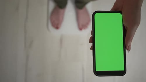 Woman Holding Phone with Green Screen on Scale