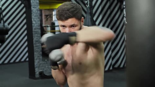 Athletic Man Boxing with Hand Weights in Gym