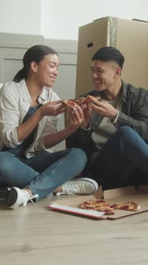 Couple Sharing Pizza on Floor in New Home