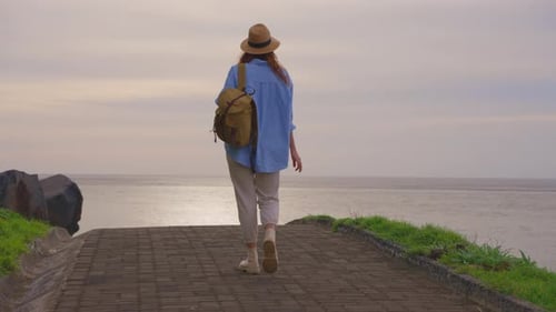 Young Adult Walking on Path Toward Ocean