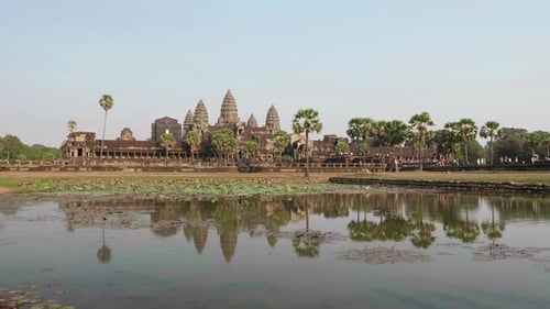 Forward Dolly Towards The Main Temple Of Angkor Wat. Recorded From The Left Pond With Reflection In