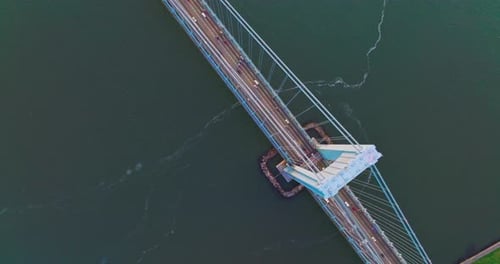 Massive huge bridge over the deep river. View from top on the bridge with transport moving quickly.