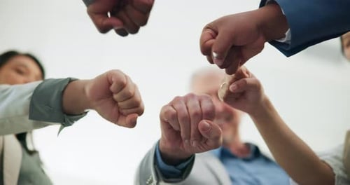 Below, business people and fist bump in office with success for company objective, goal and target